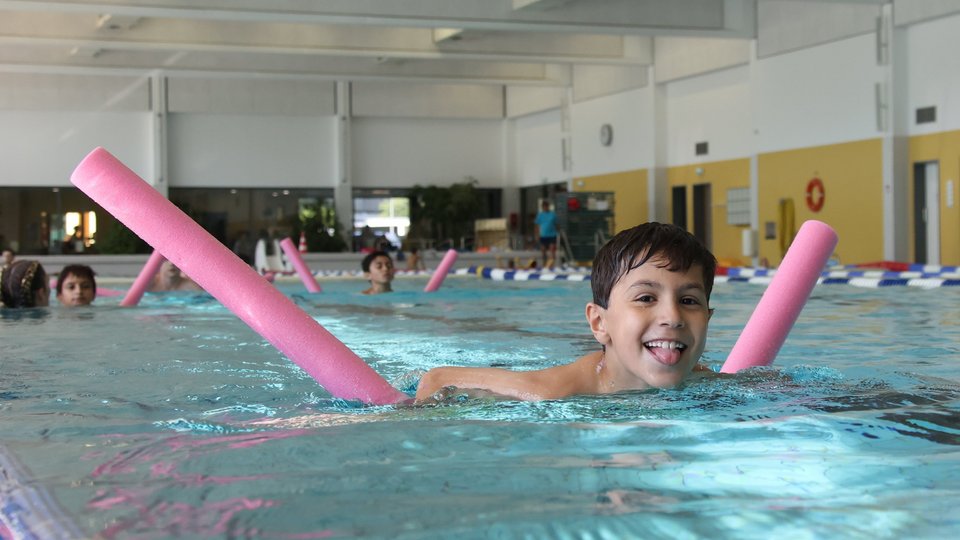 Ein Kind schwimmt mit Schwimmhilfe 